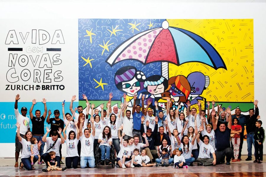 O grande painel e seus artistas —funcionários da Zurich e familiares — após um dia de pintura (Divulgação)