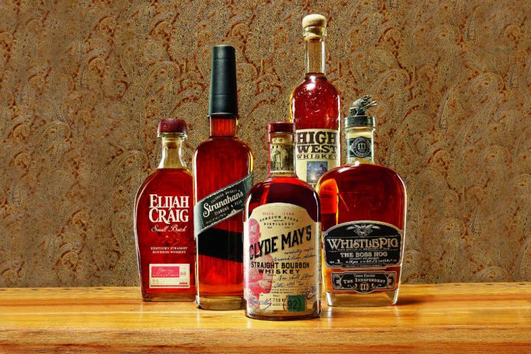 Da esquerda para a direita: Elijah Craig Small Batch Bourbon, Stranahan’s Diamond Peak Whiskey, Clyde May’s Straight Bourbon, High West Whiskey, Whistlepig The Boss Hog. Revestimento de parede Paisley da Stark. Superfície de madeira cortesia de The Hudson Company (Divulgação)