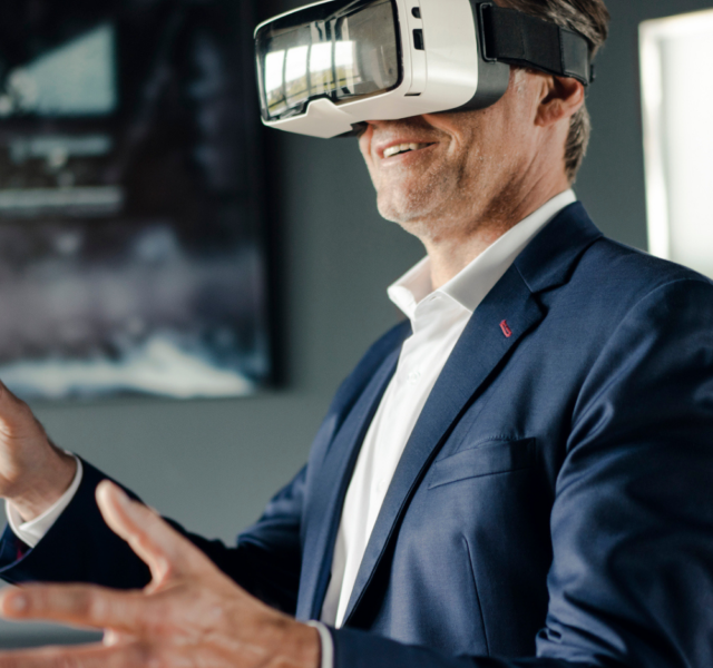 Homem branco de terno usando óculos de realidaed virtual