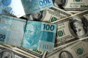 Cédulas de 100 reais e dólares