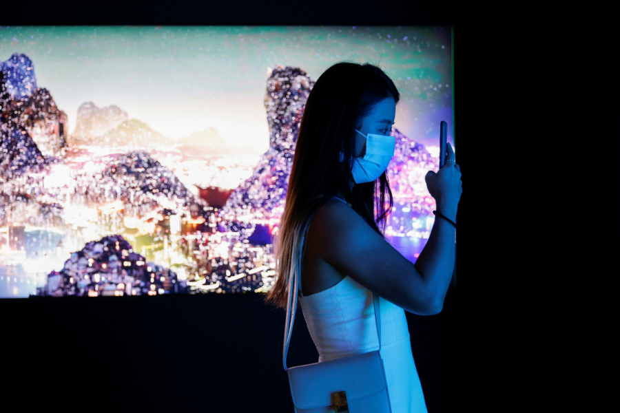 Visitante tira fotos em frente a instalação artística em vídeo, em Hong Kong
