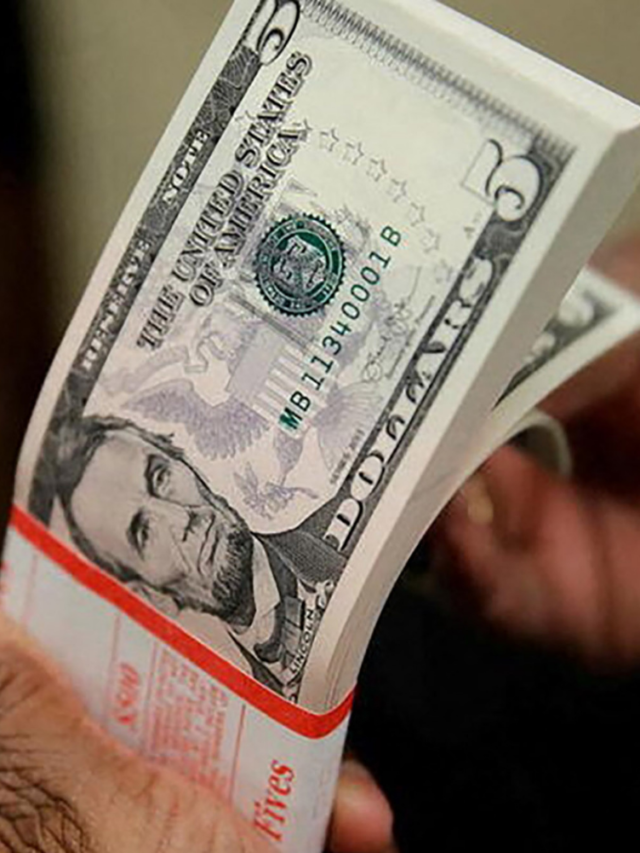Notas de dólar sendo contadas com dedo da mão