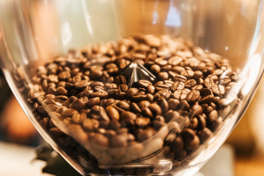 Grãos de café torrado em um recipiente incolor