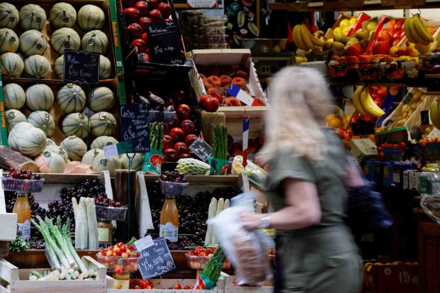 Mulher aparece fazendo compras em uma feira em Paris