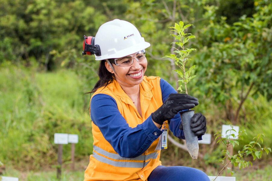 Funcionária da Atlantic Nickel segurando muda de árvore