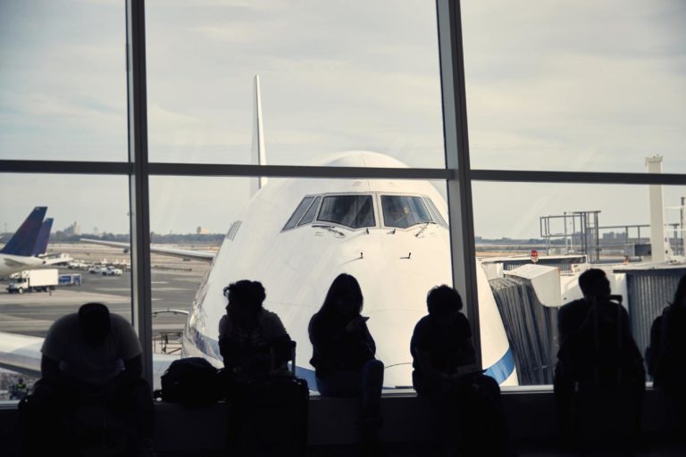 Avião é visto por passageiros que esperam em sala de embarque