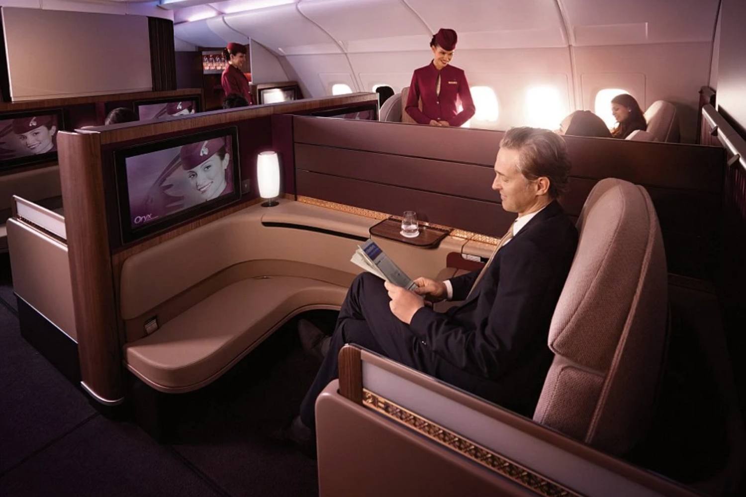 Foto de um passageiro lendo um jornal no avião da Qatar