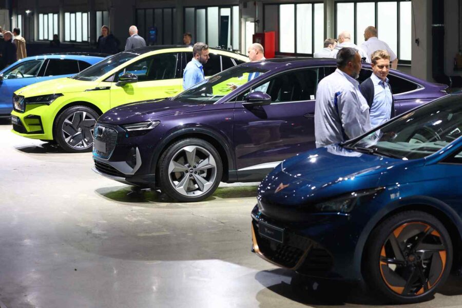 Pessoas de pé ao lado de carros elétricos coloridos