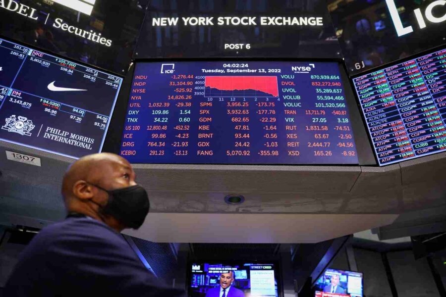 Homem passa na frente do painel de cotações na Bolsa de Nova York nos Estados Unidos.