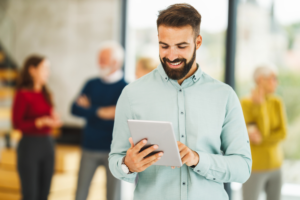 Homem branco segurando um tablet na mão direita