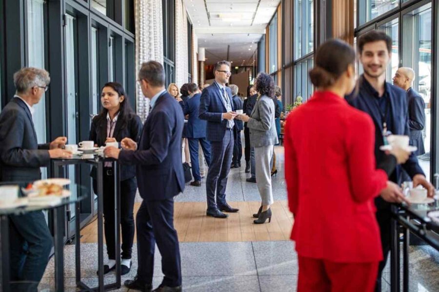 Pessoas de pé conversando em uma reunião corporativa em um escritório
