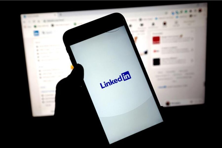 Pessoa segurando celular com aplicativo do Linkedin