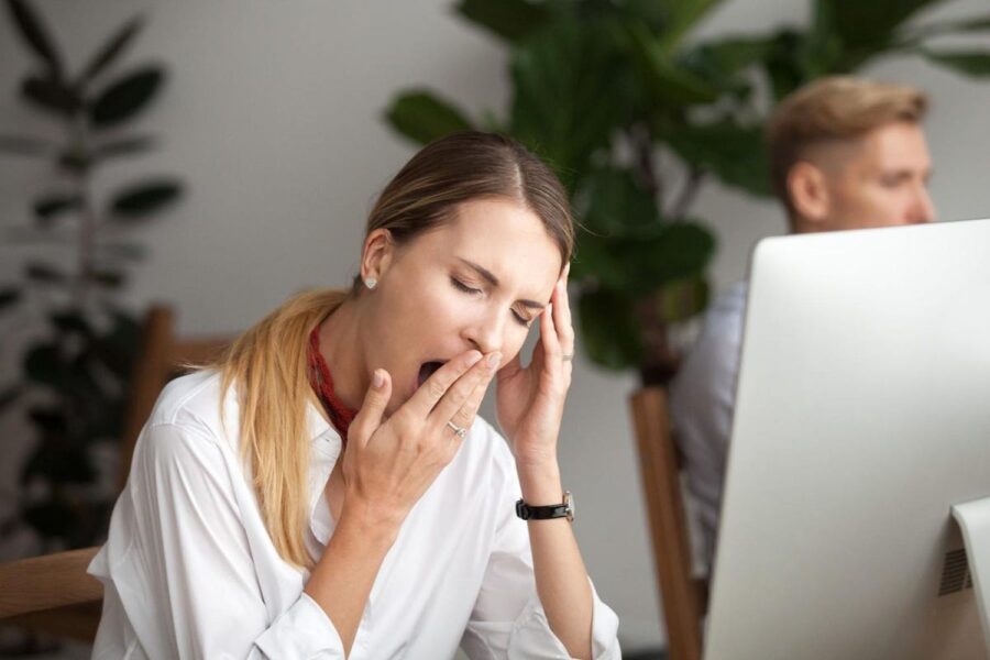 mulher loira com sono no trabalho