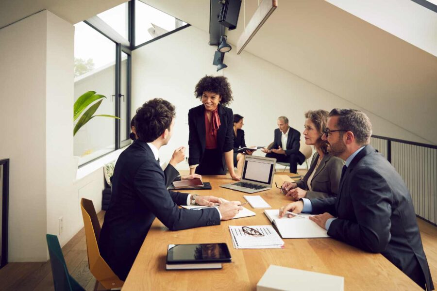Pessoas de terno sentadas em mesa e conversando