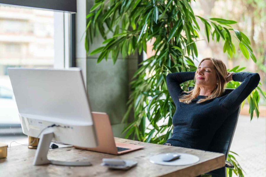 Mulher em sentada em frente ao computador relaxando