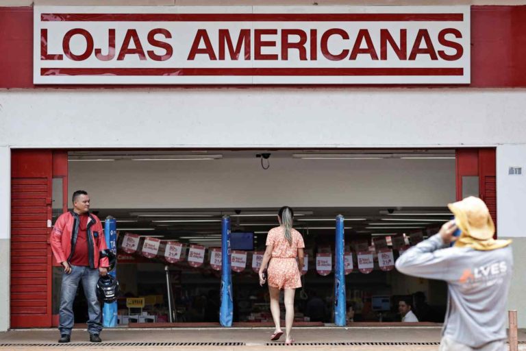 Pessoas na fachada das Lojas Americanas