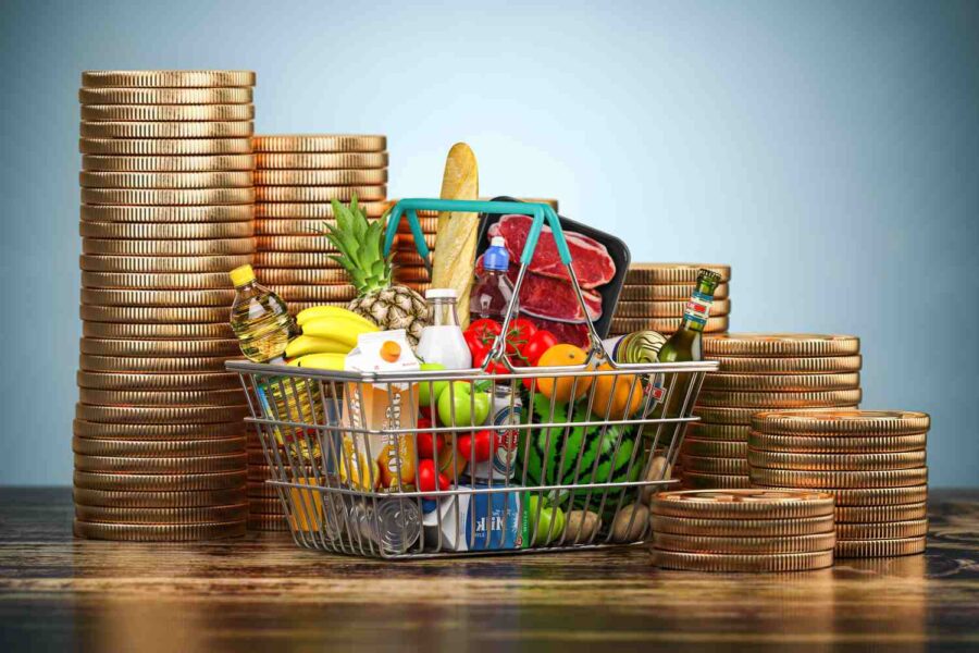 Cesta de alimentos e moedas ao fundo