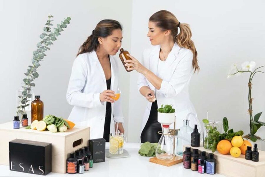 Mulheres cheiram um frasco de fragrância