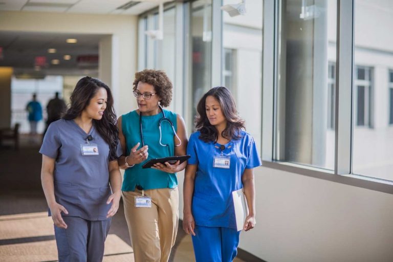 Mulheres da área da saúde andando em um hospital