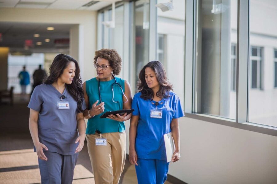 Mulheres da área da saúde andando em um hospital