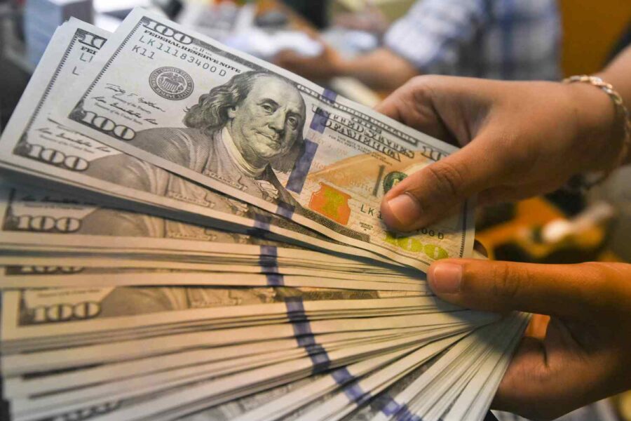 Pessoa com notas de dólar na mão