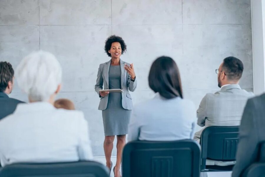 Mulher falando com confiança para uma plateia