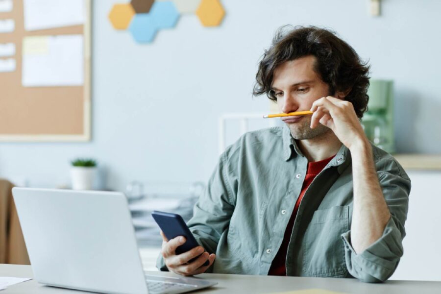 Homem no trabalho mexendo no celular