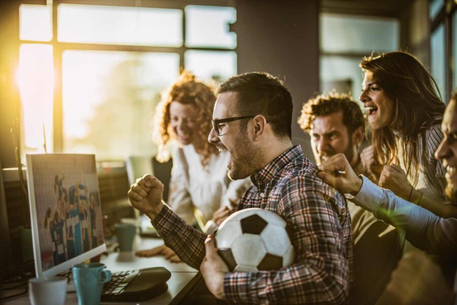 Pessoas assistindo a jogos de futebol no trabalho
