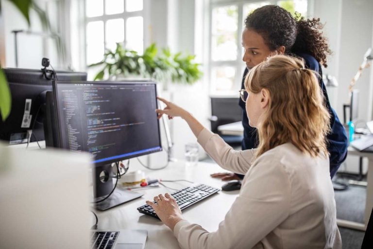 Duas mulheres trabalhando com código em computador
