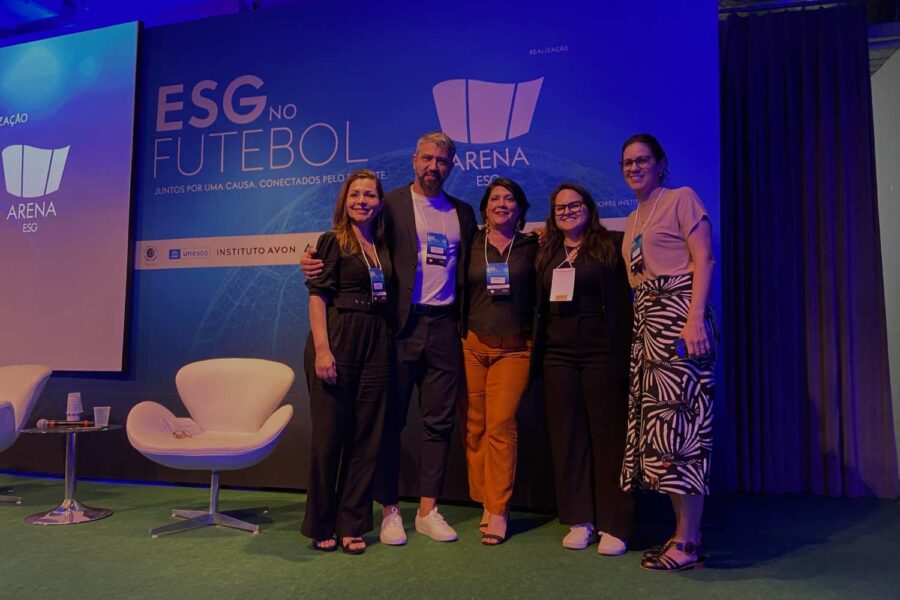 Pessoas posam para foto na frente de escrito ESG no futebol