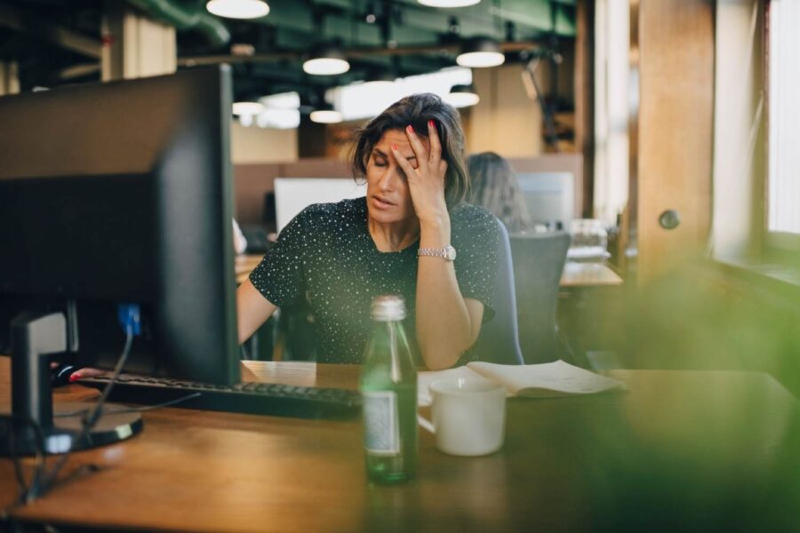Mulher cansada em trabalho presencial