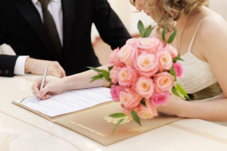 Homem e mulher assinando documentos no casamento