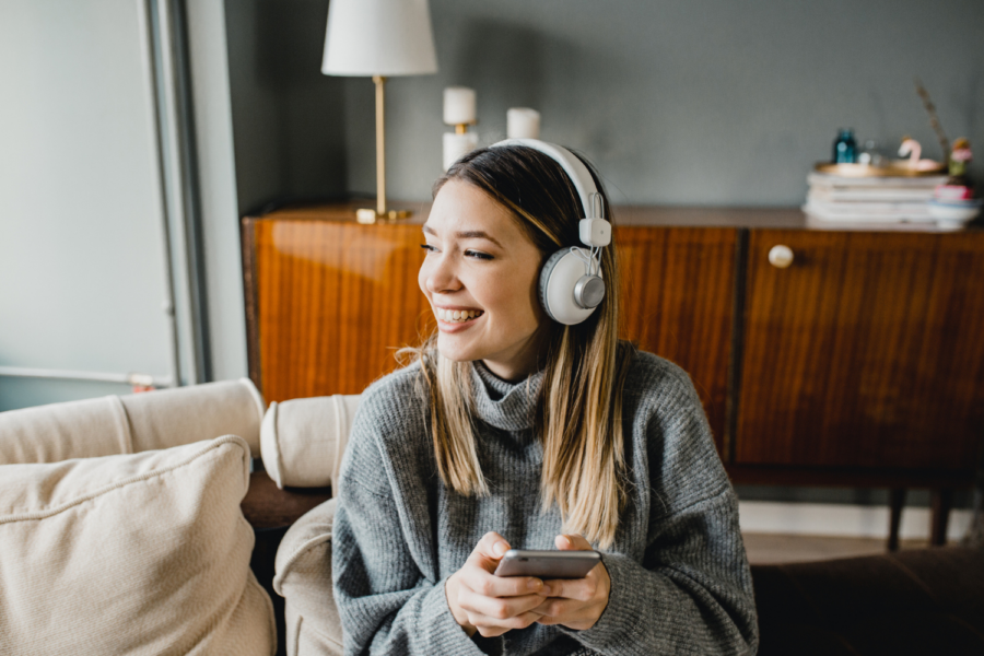 Getty Images/Mulher ouvindo podcast com fones de ouvido.