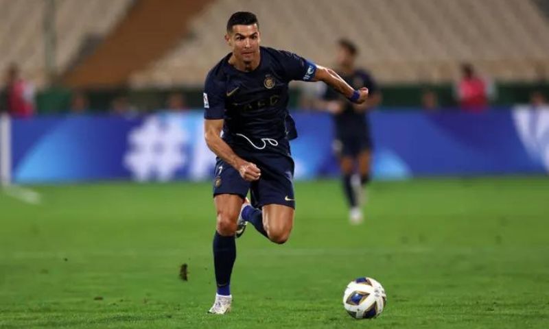 Dois jogadores de futebol jogando futebol no campo marcando um