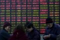 Investidores em frente a quadro eletrônico mostrando informações sobre o mercado acionário, em Xangai, China - Foto: REUTERS/Aly Song