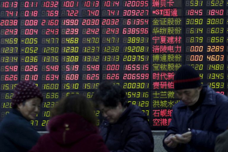 Investidores em frente a quadro eletrônico mostrando informações sobre o mercado acionário, em Xangai, China - Foto: REUTERS/Aly Song