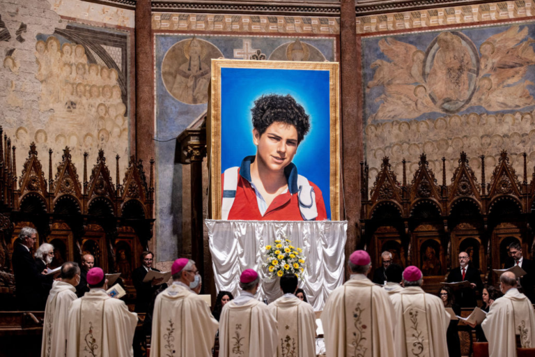 Uma tapeçaria com um retrato de Carlo Acutis pendurada na Basílica de São Francisco durante a cerimônia de beatificação do jovem em Assis, Itália. Foto: Getty Images