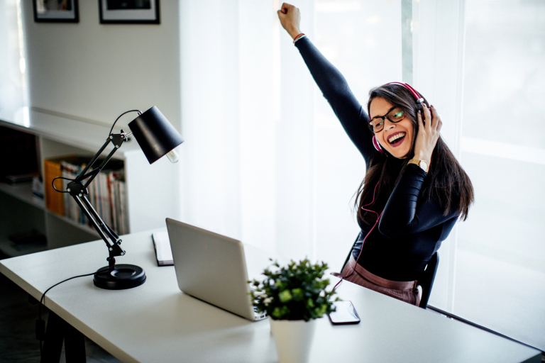 Mulher feliz durante o trabalho remoto via Canva Images