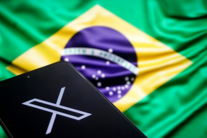 Imagem de um celular com o logo do X em frente a bandeira do Brasil