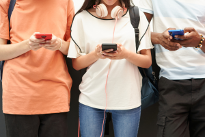 Foto ilustrativa de adolescentes utilizando o celular