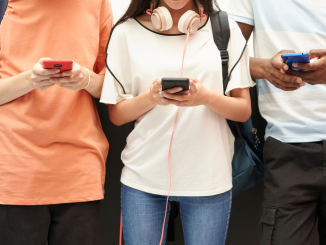 Foto ilustrativa de adolescentes utilizando o celular