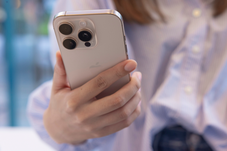 Foto de uma pessoa segurando um iPhone em uma loja da Apple em Tokyo