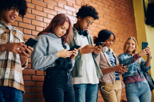 Foto de adolescentes usando o celular na escola