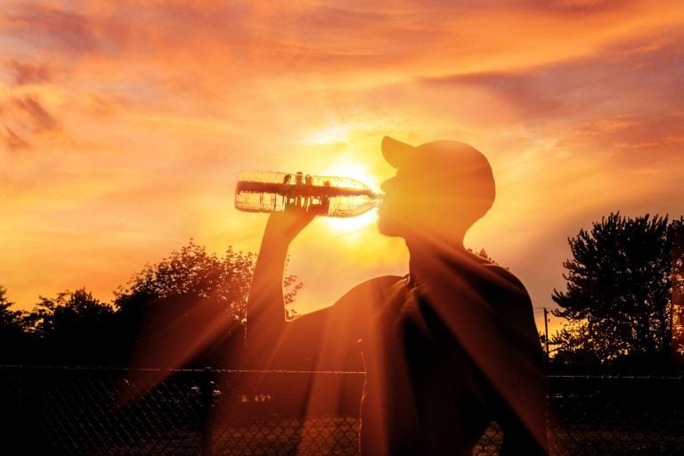 Homem bebendo água durante onda de calor