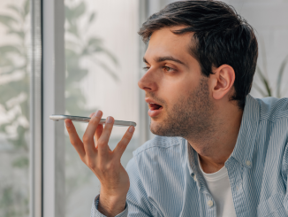 Homem utilizando um celular para fazer uma gravação de voz