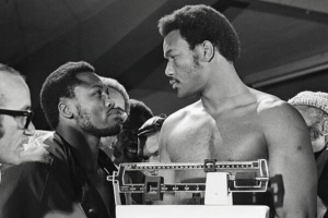 George Foreman (dir.) encarando o oponente Joe Frazier em sua primeira disputa pelo título mundial, em 1973