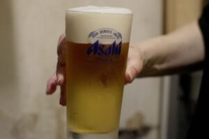 Funcionário de restaurante segura copo de cerveja Asahi Super Dry em Tóquio