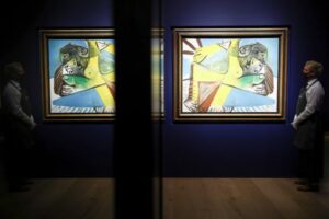 Assistente de galeria posa ao lado de obra do pintor Picasso