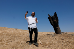 Colono israelense faz selfie ao lado de míssil iraniano: novos ataques (Foto: Ammar Awad / Reuters)