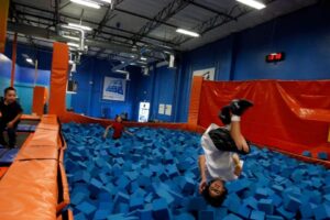 Crianças brincam na piscina de espuma da área Foam Zone do parque de trampolins indoor Sky Zone, em Anaheim, Califórnia